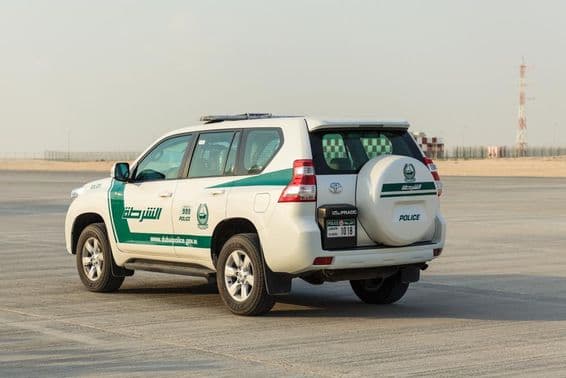 Dubai rendőrkocsi áll a betonon.