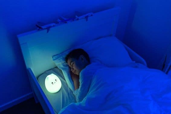 fiú alszik LED-es éjjeli lámpával.