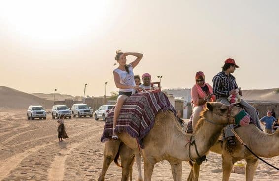 Turisták tevegelésen a sivatagban dubaiban