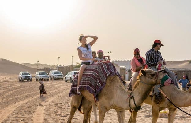 Turisták tevegelésen a sivatagban dubaiban