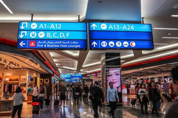 Utasok sétálnak az indulási kapukhoz a Dubai Nemzetközi Repülőtéren