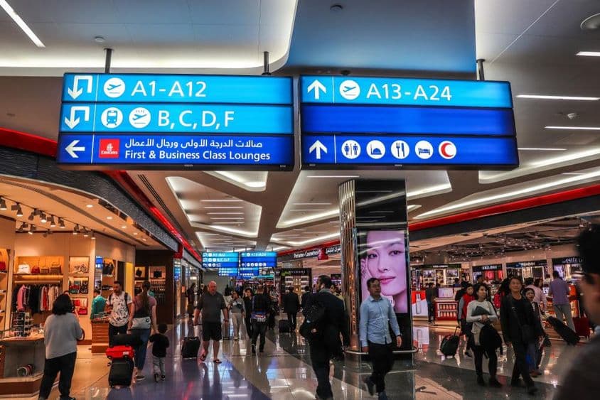 Utasok sétálnak az indulási kapukhoz a Dubai Nemzetközi Repülőtéren