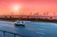 Autópálya és Dubai városképe naplementekor.