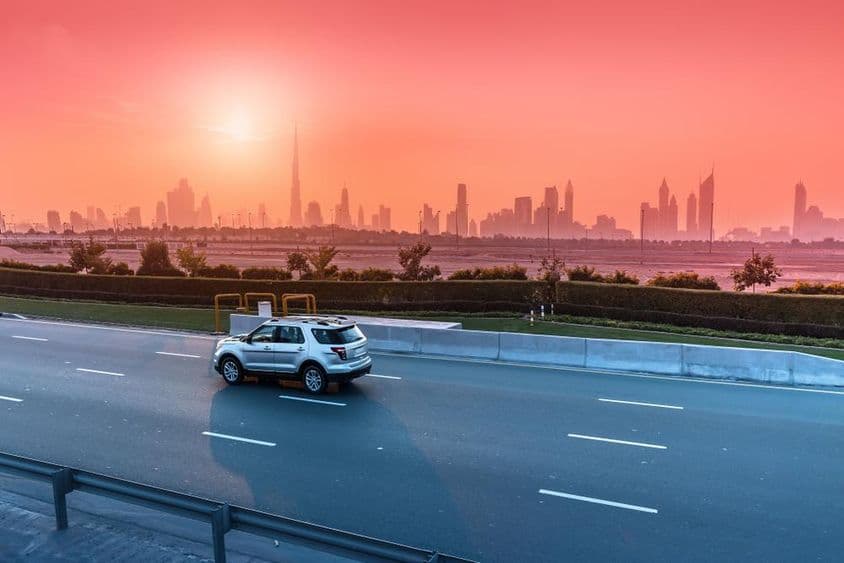 Autópálya és Dubai városképe naplementekor.